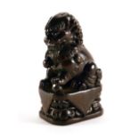 A carved hardwood figure modelled as a temple dog, h. 5.3 cm, signed with bone insert verso
