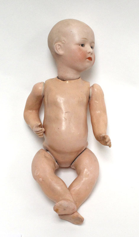 A German bisque headed doll with painted and moulded features, head indistinctly stamped, h. 22.5 cm