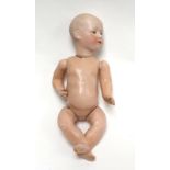 A German bisque headed doll with painted and moulded features, head indistinctly stamped, h. 22.5 cm