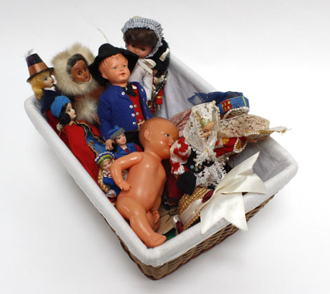 A Ma-Sit collapsible dolls pram in pink gingham containing a small group of national dolls and