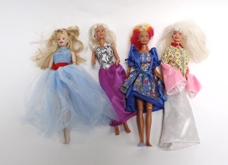 A group of seven Barbie and other plastic dolls and a small group of clothing and accessories