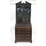 An Edwardian carved mahogany bureau bookcase, the astragal glazed doors over a fall front and an