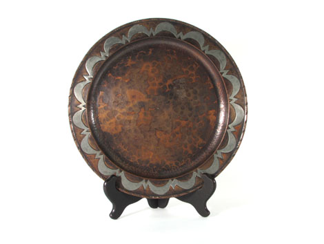 An Arts & Crafts copper plate, the raised rim with silvered decoration, by Hugh Wallace, bearing