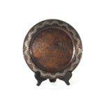 An Arts & Crafts copper plate, the raised rim with silvered decoration, by Hugh Wallace, bearing