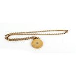 A 9ct yellow gold chainlink necklace suspending a circular yellow metal locket set centrally with a