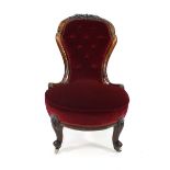 A Victorian walnut and button upholstered nursing chair on turned feet with castors CONDITION