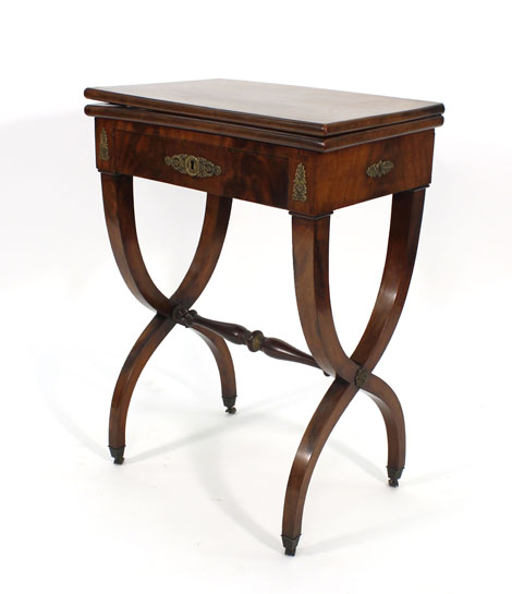 A Regency mahogany and gilt metal mounted games table, the folding top over a frieze drawer on