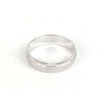 A 9ct white gold wedding band with engraved decoration, 3 gms,