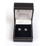 A pair of white metal earrings,