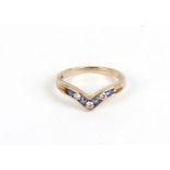 A 9ct yellow gold ring set five sapphires interspersed with three diamonds in a v-shaped channel