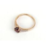 A 9ct yellow gold ring set red coloured stone and small diamonds,