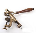 An early 20th century table-mounted brass corkscrew with a turned handle