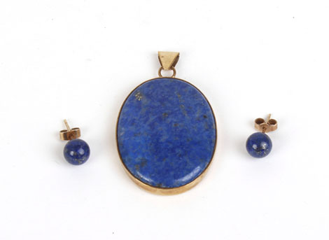 A modern yellow metal pendant of oval form set lapis lazuli,