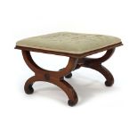 A 19th century Empire-style footstool, the upholstered top on a scrolled mahogany frame joined by