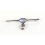 A silver bar brooch of Art Nouveau design set moonstone and suspending a further moonstone,