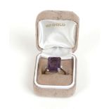 A white metal ring of Art Deco design set centrally with a baguette cut synthetic Alexandrite,