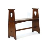 An Arts & Crafts oak bench, the two supports with heart shaped decoration and joined by a stretcher,