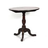 A early 19th century mahogany tilt-top supper table, the circular top on a turned column with