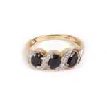 A 9ct yellow gold ring set three dark blue sapphires interspersed with small diamonds,