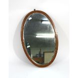 An Edwardian wall mirror, the oval plate within a mahogany and strung frame, h. 75 cm CONDITION