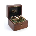 A Victorian mahogany apothecary box containing twelve green glass bottles by Leath & Ross of London,