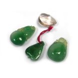 A group of three carved bright green jade pendants and a similar clear pendant, max l. 3.
