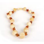 An early 20th century ivory and orange bead necklace with screw-type clasp, l. 40 cm CONDITION