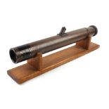 A 20th century tole telescope by Watson & Sons Ltd. mounted on an oak stand, l. 54 cm