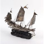 A late 19th century Chinese export metalware model of a three master junk on a carved hardwood