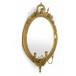 A pair of 19th century wall mirrors, the oval plate within a gilt plaster frame with three