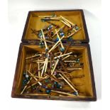 A rosewood box containing a large quantity of bone and wooden lace bobbins,