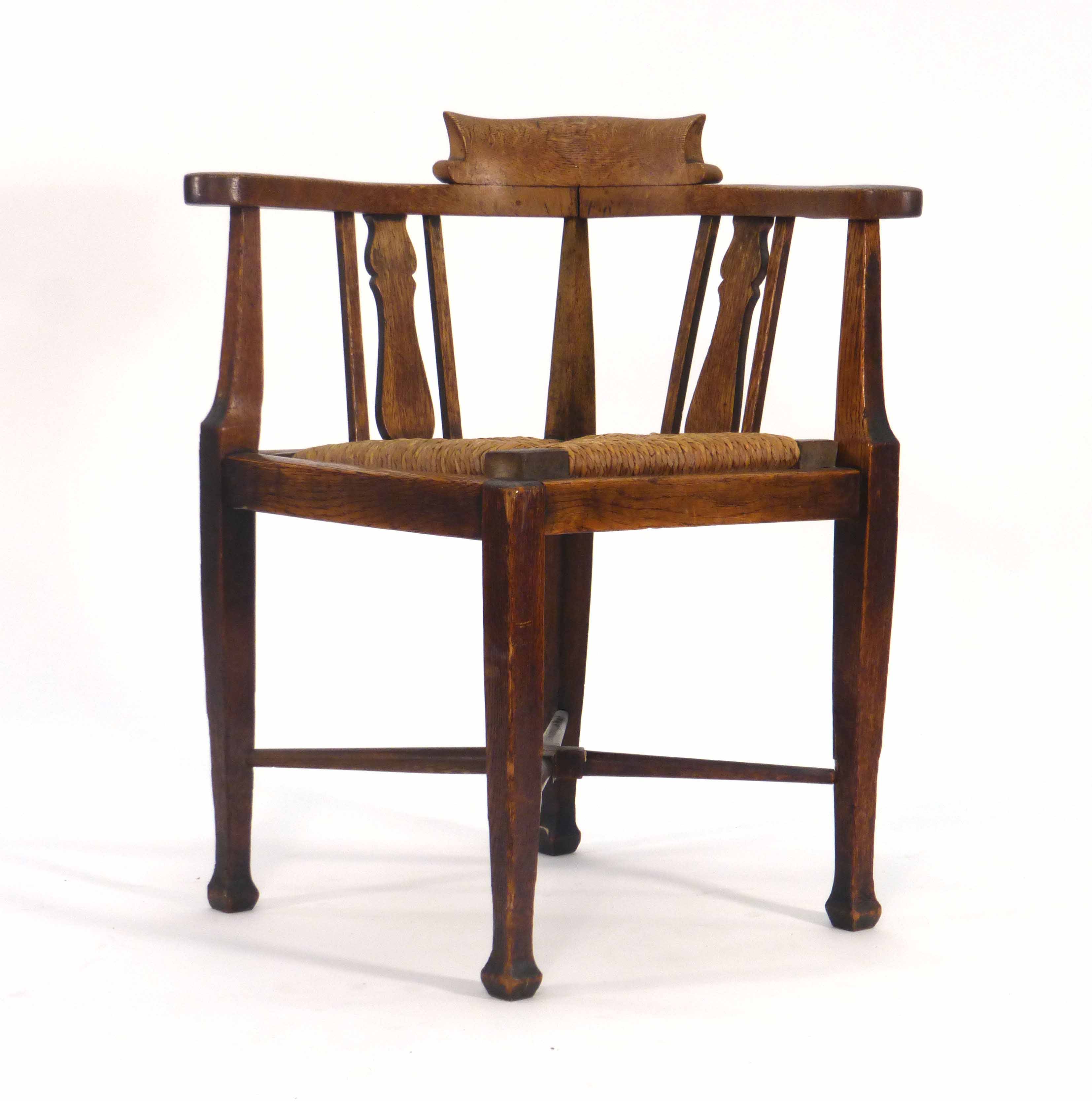 An Arts & Crafts oak corner armchair CONDITION REPORT: Wear commensurate with age, shrinkage