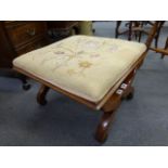 A 19th century Empire-style footstool, the upholstered top on a scrolled mahogany frame joined by