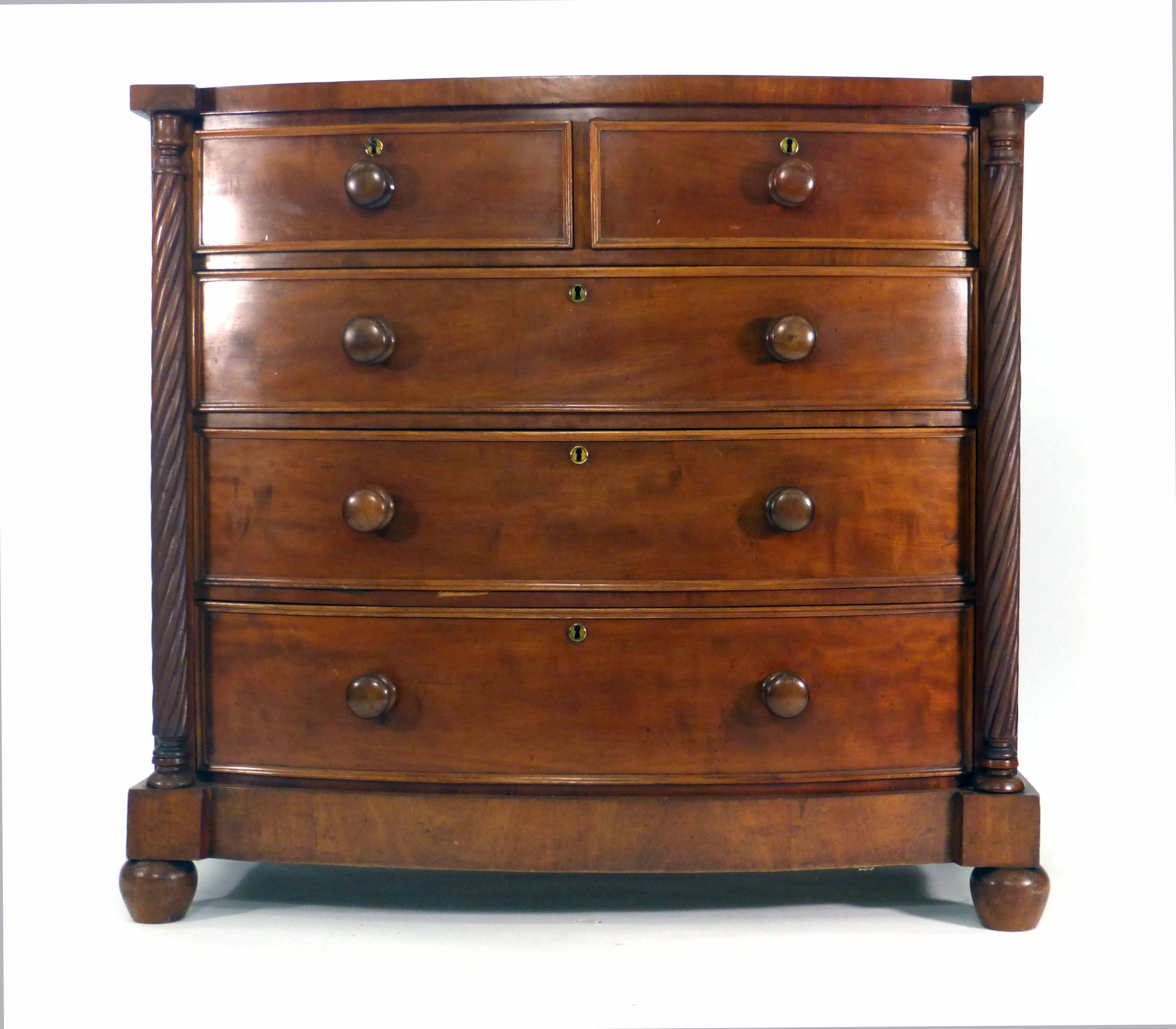 A 19th century mahogany bow fronted chest of two short and three long graduated drawers flanked by a