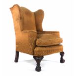 A 19th century Irish wingback open armchair on mahogany ball and claw feet CONDITION REPORT: Rips to