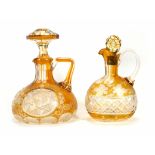 Two Victorian cut glass claret jugs and stoppers, each having etched floral decoration on a golden