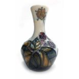 A Moorcroft spill vase of squat tapering form, the white ground relief decorated with fruiting