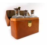 A set of three decanters contained in a tan leather travelling case by Homa, l. 22 cm CONDITION