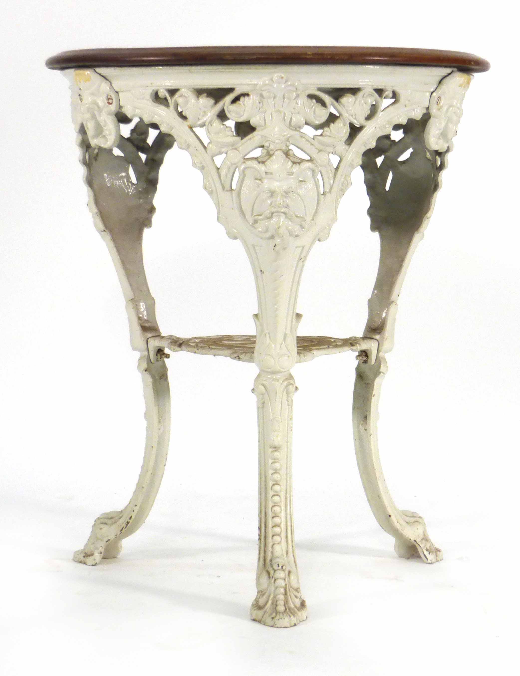 A late Victorian garden table, the mahogany circular top on a white cast iron base, the three legs