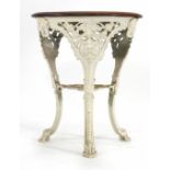 A late Victorian garden table, the mahogany circular top on a white cast iron base, the three legs