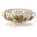 A late 19th century two handled porcelain bowl with pierced sides and relief decorated with floral