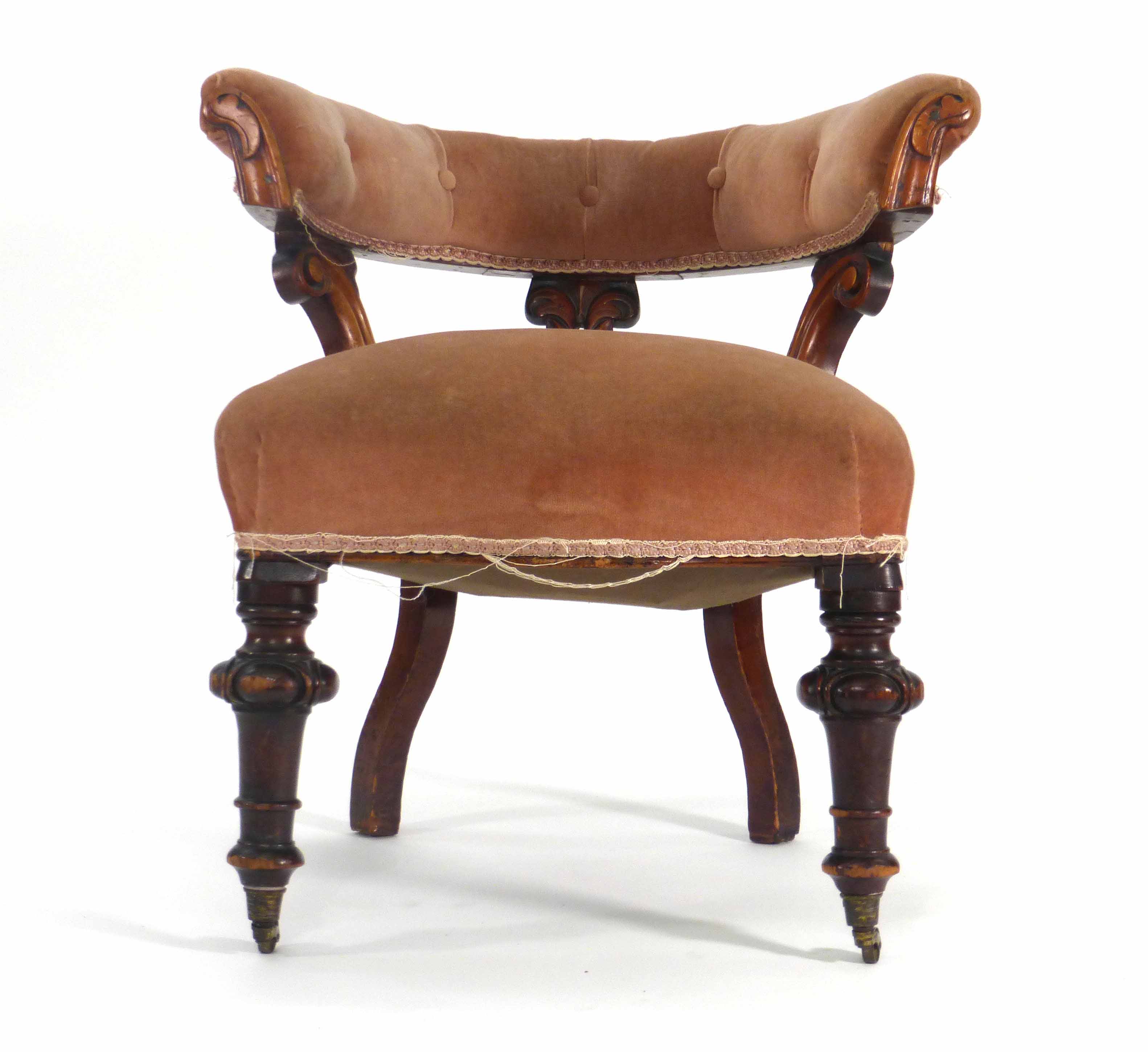 A Victorian mahogany and button upholstered club-type armchair on turned feet with castors