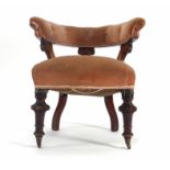 A Victorian mahogany and button upholstered club-type armchair on turned feet with castors