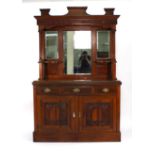 An Edwardian carved walnut and mirror backed sideboard with an arrangement of two drawers and two