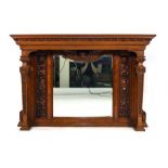 A Victorian overmantle mirror, the rectangular plate within a carved oak and walnut frame with two