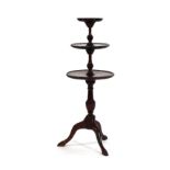 A Regency-style mahogany three tier dumb waiter on a turned support with three splayed legs