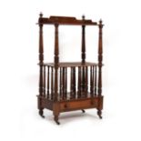An Edwardian mahogany three-tier Canterbury with turned supports over a single drawer on castors, w.