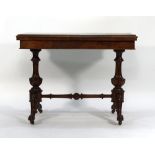 A Victorian figured walnut folding games table on scrolled supports joined by a cross stretcher,