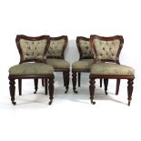 A set of four Victorian mahogany and button upholstered dining chairs on turned and reeded legs