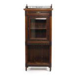 An Edwardian mahogany and fretwork music cabinet with a single drawer over a glazed door and an open